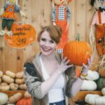 Bryce Dallas Howard Instagram - Hey, October 😉🍂⁣⁣ ⁣⁣ 📸: @andiejjane⁣⁣ ⁣⁣ [ID: BDH playfully poses in front of a display at @traderjoes with pumpkins of all different shapes, sizes, and colors. In full autumn vibes, she wears navy blue jeans, a white t-shirt, and a beige and brown cardigan. 3 smiling scarecrows hang on the wall in the back.]⁣