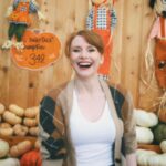 Bryce Dallas Howard Instagram - Hey, October 😉🍂⁣⁣ ⁣⁣ 📸: @andiejjane⁣⁣ ⁣⁣ [ID: BDH playfully poses in front of a display at @traderjoes with pumpkins of all different shapes, sizes, and colors. In full autumn vibes, she wears navy blue jeans, a white t-shirt, and a beige and brown cardigan. 3 smiling scarecrows hang on the wall in the back.]⁣