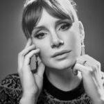 Bryce Dallas Howard Instagram – Reflections on the new year, new moon, and my new favorite phrase: “My social battery is dead” — all in this week’s edition of #TheMuse newsletter from @ninemusesentertainment. To read, subscribe at the 🔗 in bio⁣⁣
⁣⁣
📸: Austin Hargrave (@austinhargrave) for @hollywoodreporter ⁣
⁣⁣
[ID: A black and white photo of BDH sitting in The Hollywood Reporter photo studio at the Toronto International Film Festival. BDH looks pensively into camera with her head slightly tilted to the left and both hands gently resting on her face. She wears a patterned striped dress and hair in a ponytail.]