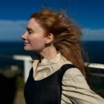 Bryce Dallas Howard Instagram - Going into 2024 like... [ID: In a close-up profile, BDH stands with her eyes closed as the Australian summer breeze sweeps her hair back. She dresses in cream and navy linen and a slight smile grows on her face. In the background, the bright blue waters of Byron Bay.]
