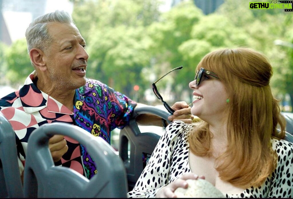 Bryce Dallas Howard Instagram - Happy Birthday to the man with a timeless sense of style, humor, grace, and genius — @jeffgoldblum, you are truly one of the greats!! 🥳🎂 ⁣ ⁣ [ID: Jeff Goldblum and BDH talking and smiling while on an open-air bus in Mexico City for #JurassicWorldDominion press. Jeff wears a multi-colored shirt with vibrant patterns and BDH wears a white dress with black spots] 📸: @universalpictures