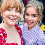 Bryce Dallas Howard Instagram - Happy Birthday @iamizzysermon! 🎊🥳 Watching you grow into the radiant, funny, insightful, and kind young woman that you are has been one of the greatest joys of being your on-screen mum 🥹 ⁣ ⁣ [ID: Doing press for Jurassic World Dominion, BDH and Izzy, smiling cheek to cheek, take a selfie together. BDH wears a dress with a red rose print and Izzy wears a lilac checkered dress.]