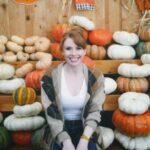 Bryce Dallas Howard Instagram - Hey, October 😉🍂⁣⁣ ⁣⁣ 📸: @andiejjane⁣⁣ ⁣⁣ [ID: BDH playfully poses in front of a display at @traderjoes with pumpkins of all different shapes, sizes, and colors. In full autumn vibes, she wears navy blue jeans, a white t-shirt, and a beige and brown cardigan. 3 smiling scarecrows hang on the wall in the back.]⁣