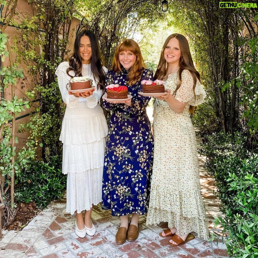 Bryce Dallas Howard Instagram - Thank you @sweetlaurelbakery for the delicious treats 💖 I never knew how soothing cake decorating could be… and next time I’ll start my design with the end in mind 😅 I hope The Great British Bake Off would be proud.⁣⁣ ⁣⁣ @laurelgallucci and @clairethomas, it’s always a joy to hang out with you and I can’t wait for Sweet Laurel to grace the shelves of our grocery stores soon! ⁣⁣ ⁣⁣ [ID 1: Living her cottage-core dreams, BDH stands between Laurel Gallucci and Claire Thomas (co-founders of Sweet Laurel Bakery) in a picturesque garden. They each hold a chocolate cake decorated with roses and raspberries.]⁣⁣ ⁣⁣ [ID 2-3: BDH twirls and shows off her new Sweet Laurel apron and canvas tote.]⁣⁣ ⁣⁣ [ID 4: A stack of Sweet Laurel Bakery’s upcoming chocolate cake, pancake, and scone mix boxes.]