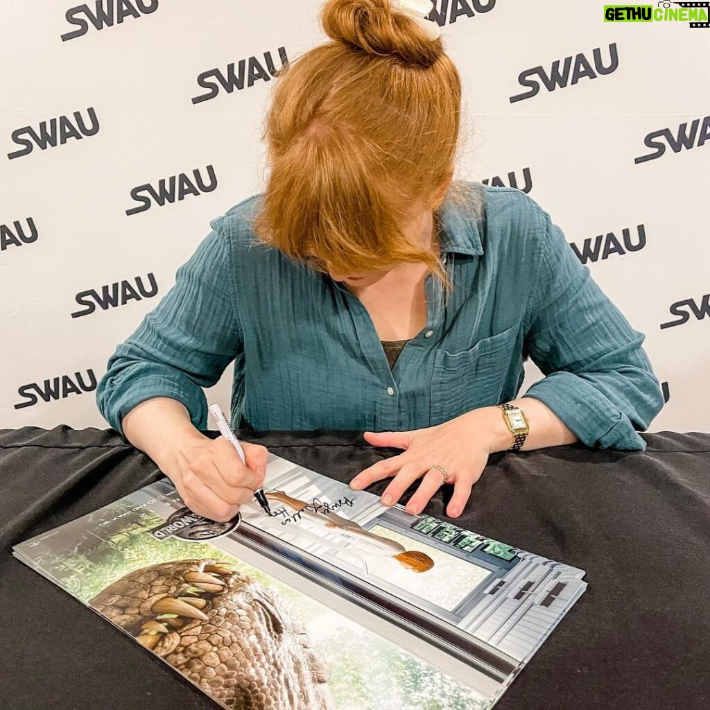 Bryce Dallas Howard Instagram - 8 hours of signatures later 😅 It means the world that fans across the movie multiverses want to memorialize these stories!! Thank you @swau_official for organizing such a fantastic signing day — my inner fangirl had the time of her life⁣ ⁣ and p.s. @missmistyrosas, @chrisfbartlett, @therealbrendanwayne, and @lateefcrowderdossantos: it’s always an honor to put my signature next to yours ❤️⁣ ⁣ [ID: BDH, wearing a linen teal button down blouse, smiles as she signs a Claire Dearing / Jurassic World poster]