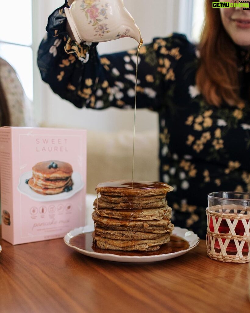 Bryce Dallas Howard Instagram - “Keep pouring,” they said 🤣 Upgrading my Sunday brunch game with @sweetlaurelbakery’s simple and delicious pancake mix 💕 Gluten-free, dairy-free, and paleo, there’s no going wrong here — place your order today at Sweet Laurel’s website in my bio:)⁣ ⁣ (not an ad, just a MASSIVE fan!)⁣ ⁣ [ID: BDH is living out her breakfast dreams as she pours a pitcher of syrup over a stack of Sweet Laurel pancakes. Smiling, she wears a navy dress with a peach and white floral pattern.]