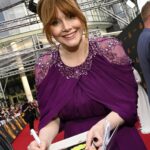 Bryce Dallas Howard Instagram - Dinosaurs, but make it fashion 🦖 Thank you Germany for being an incredible last stop on this leg of our international travels!! Next stop, home sweet home: Los Angeles! #JurassicWorldDominion ⁣ ⁣ Makeup: Kara Bua (@karayoshimotobua) ⁣⁣⁣⁣⁣ London/ Germany Hair: Christian Wood (@cwoodhair)⁣⁣⁣ Manicure: Ariane Brimah⁣ And special thanks to @alex.schack✨⁣ ⁣ [ID 1 & 2: BDH signs autographs, wearing a plum floor-length Pamella Roland gown with fancy silver beading along the neckline and sleeves.]⁣ ⁣ [ID 3: In front of a dinosaur installation in Trafalgar Square, BDH wears a bright tennis-ball yellow Alex Perry dress with an angular silhouette and neck cutout]⁣ ⁣ [ID 4 & 5: Rexy and BDH roar in Germany; BDH wears a midi red Valentino dress with matching red pumps that made her very tall]⁣ ⁣ [ID 6: Izzy Sermon, BDH, and Laura Dern speak at the London crew screening of Jurassic World Dominion. BDH wears a caramel-hued Self Portrait mesh midi dress and black blazer. She’s emotional saying thank you to all the people]