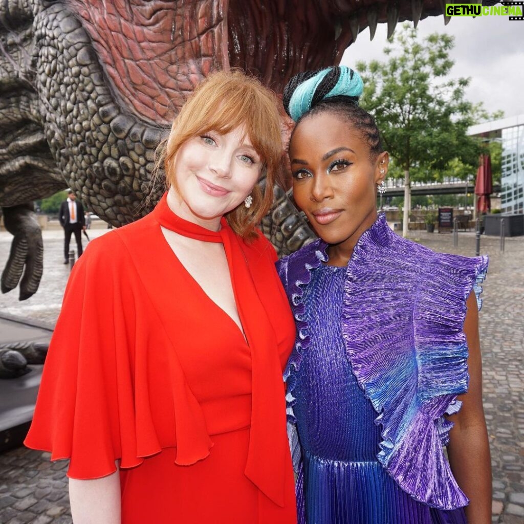 Bryce Dallas Howard Instagram - @dewandawise 💜 You are a light and a life force. Your presence makes waves. Your wisdom and truth-telling speak to the soul. You inspire us all to show up and lead with love. I am so blessed to call you a friend and artistic kindred. Happy Happy Happy Birthday DeWanda 🎉✨⁣ ⁣ [ID: At the Jurassic World Dominion photo call in Germany, Bryce and DeWanda Wise stand in front of a roaring T-Rex. Bryce, smiling on the left, wears a red dress and DeWanda, smizing on the right, wears an effervescent blue and purple gown]