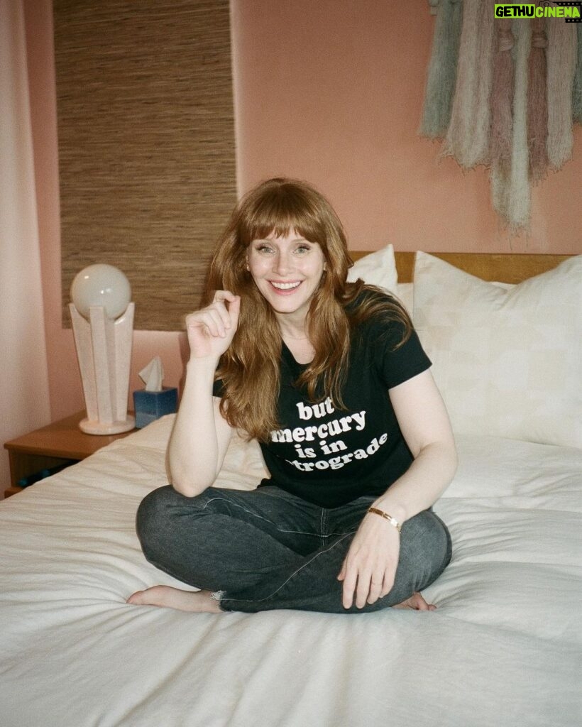 Bryce Dallas Howard Instagram - Mercury is Retrograde! In Virgo! To use the words of astrologer and writer @chaninicholas, “Good luck to us all!”⁣⁣ ⁣ 📸: Andie Jane (@andiejjane)⁣⁣ ⁣⁣ [ID: BDH sits cross-legged on top of a fluffy white comforter. She points to her black t-shirt which reads, “but mercury is in retrograde.”]