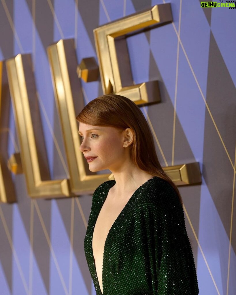 Bryce Dallas Howard Instagram - London, you make my heart so full! ❤️ #ArgylleMoviePremiere⁣ ⁣⁣ 📸: Getty Images for Universal Pictures Hair: @cwoodhair⁣⁣ Makeup: @karayoshimotobua⁣⁣ Styled by Publicist Extraordinaire: @alex.schack⁣⁣ ⁣⁣ [ID: In front of blue and yellow Argylle-themed backdrops, BDH poses for photos at the UK premiere of #ArgylleMovie. She wears a long, glittering emerald green dress with a deep v-neckline and deep crimson lipstick. Her straightened hair falls behind her back to show off her earrings.] Odeon Luxe Leicester Square