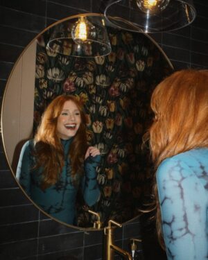 Bryce Dallas Howard Instagram - Many things to toast this weekend 🥂 A @universalpictures family reunion for the ages, 3 weeks until the @argyllemovie premiere, a fresh haircut from @misterjasonlow, and most importantly, my hot date @stealthgabel 💋

📸: @andiejjane 

[ID: Debuting a middle part after many, many years, BDH wears her hair down and a fitted long-sleeve dress with a moss & black dye print. As she gets ready for the Universal Pictures party, she takes photos around the house and with the ever-handsome Seth Gabel.]