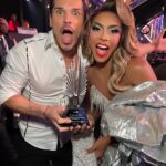 D.J. "Shangela" Pierce Instagram - Reconnecting with my @glebsavchenkoofficial in the @dancingwiththestars ballroom tonight was such a MOMENT!! We even finally had a chance to take a photo accepting the @glaad award trophy that we were awarded earlier this year for LGBTQ+ and ally visibility. #TeamHalleloo for LIFE! ❤️ Dress @waltercollection Detailing @creative.couture.tailoring Makeup @lushiousmassacr Wig Stylist @walliecruz Wig creator @itssammyhair Photog @liamrileycb