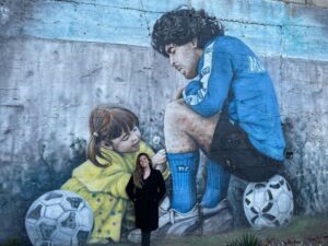 Dalma Maradona Instagram - Y con esta foto les cuento que terminamos de filmar!! Hermoso lugar elegido para terminar el rodaje! Y más allá de lo que paso con el estadio 🤦🏼‍♀️ agradezco el amor de todos los napolitanos para mi papá y en consecuencia para mi ! Me voy con el corazón explotado de amor! Es inexplicable lo que pasa en esa ciudad con el! Recibir tanto amor fue hermoso! Este es un homenaje con todo mi ❤️ y para que por fin lo que se  muestre sea la verdad y QUE HABLÉ LA GENTE QUE LO CONOCIÓ Y VIVIÓ MOMENTOS IMPORTANTES CON EL! 🎥❤️ ME ENCONTRÉ CON EL AUTOR  @mario_casti_  QUE ME DIO PERMISO PARA INTERVENIR SU OBRA! Podes darte cuenta que fue lo que hice? 😂❤️