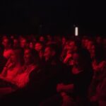 Danila Poperechny Instagram - Отработал 2 стадионных концерта: в Дубае и Вильнюсе. Идентичный материал, который я читал уже больше 30 раз, не считая сколько он обкатывался по частям на оупенах. И эти два концерта стали для меня отличным примером того, насколько же иногда по разному заходит один текст на разную аудиторию. Казалось бы - понятная истина для любого человека, но как же сложно порой бывает принять это, когда ты "автор произведения". Не сказал бы, что с концертом в Дубае было что-то не так - он был норм. Но вот именно, что "норм". Так вышло, что он был одним из тех, на котором часть материала просто "не попадала" в некоторую публику, из-за чего на выступлении постоянно было ощущение, что нам всем не удается запрыгнуть на одну волну. Например я видел, как из зала несколько раз вставали и уходили люди, как только начинали звучать блоки, безотказно работающие в других залах до этого. Уходящих было совсем не много и уходили они под звуки смеха остального зала, но они были и я естественно их замечал. Обычно, после подобного я провожу работу над ошибками, пытаясь понять, что же я сделал не так. Не так подал, не с теми интонациями говорил шутки, не достаточно расположил зрителя в начале, забыл какие-то важные блоки, может был слишком уставший на сцене, возможно материал устарел и тд. Но в этот раз я решил абсолютно ничего не менять и провести концерт в Вильнюсе точь в точь, как в Дубае, чтобы проверить, в чем же было дело. Я так и сделал, и, к моему сюрпризу, выступление прошло просто потрясающе. Большой стадион в полторы тысячи человек, который был еще больше, чем зал в Дубае - реагировал гораздо вовлеченнее, громче и теплее на те же самые вещи, которые вообще не вызывали отклика у некоторых дубайских зрителей. Единственный поинт, который хотелось сегодня высказать - рефлексия это, конечно, хорошо. Людям, которые создают что-то, жизненноважно находиться в постоянном самоосмыслении и анализе того, как становиться лучше. И это правильно, потому что неудачи будут преследовать вас на пути регулярно, и нет ничего важнее чем то, чтобы вынести из них как можно больше опыта. Но не забывайте, что иногда все дело может быть в том, что "в зале просто не совсем ваша публика". 📷@makslonglive