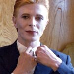 David Bowie Instagram - Not much evidence of a mirror in this first shot from 1975 of Bowie as Thomas Jerome Newton, until you look at those famous eyes. All is revealed in the uncropped image as Geoff MacCormack is seen taking the shot in David’s changing room on the set of The Man Who Fell To Earth. Have you read Geoff’s book DAVID BOWIE: ROCK 'N' ROLL WITH ME? It’s a touching account of a lifelong friendship, peppered with Geoff’s extraordinary shots of David at work, rest and play: https://bit.ly/RockNRollWithMeBook (Linktree in bio) #BowieReflections