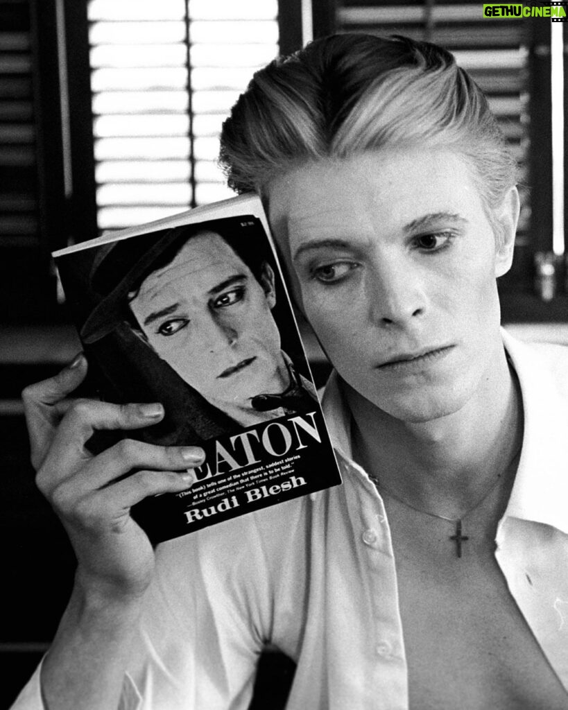 David Bowie Instagram - BOWIE’S BUSTER KEATON TRIBUTES “He’s Chameleon, Comedian, Corinthian and Caricature…” The first image here is another fine Steve Schapiro portrait from 1975. As you can see, David is pictured with Rudi Blesh‘s biography of Buster Keaton. Schapiro remembers how David was impressed with the photographer’s connection to Keaton: “From the moment Bowie arrived, we seemed to hit it off. Incredibly intelligent, calm, and filled with ideas, he talked a lot about Alistair Crowley whose esoteric writings he was heavily into at the time. When David heard that I had photographed Buster Keaton, one of his greatest heroes, we instantly became friends.” Bowie even used a full-page 1964 Schapiro shot of Keaton in New York inside the 1976 Isolar Tour programme. (2nd image) Bowie references Keaton in at least a couple of his videos. In the 1977 Stanley Dorfman-directed Be My Wife promo, he performs against a bleached-out background in this heartfelt plea for marital union and somehow manages to appear nonchalant and anguished at the same time. Apparently, Bowie’s make-up and mannerisms in the video were a nod to Buster himself. (3rd image) The Keaton look was reprised more obviously and to wonderful effect throughout the Miracle Goodnight video in 1993. (4th image) A couple more images may or may not have been as a result of David watching Keaton’s movies. Perhaps the links are a little tenuous, but here they are anyway. The 5th image is Sukita’s famous shot from 1973 wherein Bowie mirrors Keaton’s pose in the film The High Sign. (6th image) The 7th slide is the 1971 edition of the KEATON paperback that Bowie is holding in the first image and the still of Keaton as a sailor is from the film The Navigator. Finally, the last picture by @blamsnap is from the 2000 BowieNet Roseland concert when Bowie dressed nautically, Sailor being his chatroom nickname. KEATON is a book that David was clearly fond of, but it’s another that didn’t make it into BOWIE’S TOP 100 BOOKS - THE COMPLETE LIST: https://www.davidbowie.com/blog/2013/10/1/bowies-top-100-books-the-complete-list (Linktree in bio) #BowieBookLover #BowieSchapiro #BowieKeaton