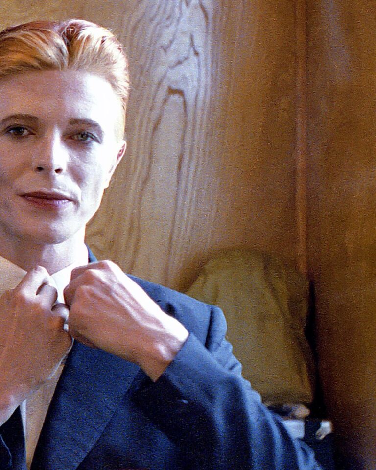 David Bowie Instagram - Not much evidence of a mirror in this first shot from 1975 of Bowie as Thomas Jerome Newton, until you look at those famous eyes. All is revealed in the uncropped image as Geoff MacCormack is seen taking the shot in David’s changing room on the set of The Man Who Fell To Earth. Have you read Geoff’s book DAVID BOWIE: ROCK 'N' ROLL WITH ME? It’s a touching account of a lifelong friendship, peppered with Geoff’s extraordinary shots of David at work, rest and play: https://bit.ly/RockNRollWithMeBook (Linktree in bio) #BowieReflections