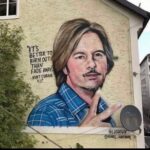 David Spade Instagram – I think this is going around again. The picture of me on a building in Austria by an artist. He says its kurt Cobain the quote is wrong also. Its from neil young ( i think). It’s kind of funny and meant to be confusing. #tadah.