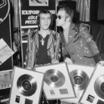 Elton John Instagram - ”Don't Shoot Me I'm Only The Piano Player” was our first No.1 record in the UK, and second in the US. Here is a photo of @bernietaupinofficial and me with some of our first gold records in 1973 (little did we know how great our collection would become). 📸@michaelputlandphotography