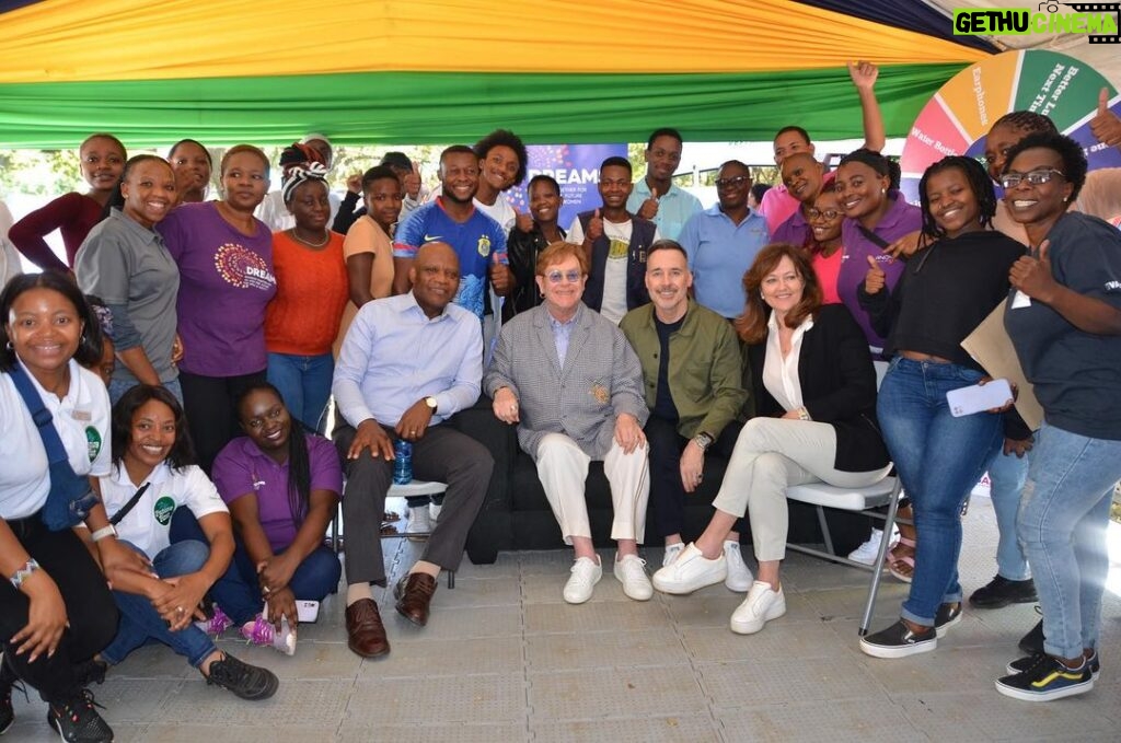 Elton John Instagram - What a week it’s been visiting @ejaf and @pepfar HIV prevention and care projects in Johannesburg with Congress leaders to celebrate what the past 20 years of funding has achieved – saving lives and creating brighter futures for millions of people. @davidfurnish and I were thrilled to meet so many young people taking part in @ejaf programmes. Through innovative tech we are helping young people talk about sex, love and relationships and supporting their mental and sexual health. The future is theirs for the taking! We must keep our foot on the accelerator to continue this remarkable progress in partnership with @pepfar. My thanks go to all of the amazing medical staff, youth mentors, educators and of course those wonderful young people we met along the way. Til next time South Africa! #HIV #AIDS #PEPFAR20 #Triggerise #BWiseHealth #Praekelt