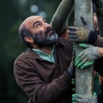 Houman Seyyedi Instagram - جنگ جهانی سوم در راه است/درباره آخرین ساخته هومن سیدی، معرفی عوامل فیلم و انتشار اولین تصویر . فیلم سینمایی «جنگ جهانی سوم»، به نویسندگی هومن سیدی، آرین وزیردفتری و آزاد جعفریان و کارگردانی و تهیه‌کنندگی هومن سیدی این روزها در شمال کشور در حال فیلمبرداری است. این اولین تجربه تهیه‌کنندگی هومن سیدی است و محسن تنابنده، ندا جبرئیلی، مهسا حجازی، نوید نصرتی، لطف‌الله سیفی و حاتم مشمولی از جمله بازیگرانی هستند که در «جنگ جهانی سوم» به ایفای نقش پرداخته‌اند. این اولین حضور محسن تنابنده مقابل دوربین هومن سیدی است. در واقع تنابنده تنها بازیگر ستاره فیلم سیدی است که با یک بازی متفاوت در نقشی سخت به هنرنمایی پرداخته و سیدی مثل پروژه‌های دیگرش این بار هم سراغ یک سری چهره جدید و نوظهور رفته است. در خلاصه داستان این فیلم آمده «من همونی هستم که لباس تنت کرد، آدمت کرد، بهت بها داد، من همونم...» از عوامل اصلی که در این فیلم سینمایی هومن سیدی را همراهی می‌کنند می‌توان به حضور پیمان شادمان‌فر به عنوان مدیر فیلمبرداری، مهران ملکوتی، مدیر صدابرداری و محسن نصرالهی، طراح صحنه اشاره کرد که در واقع چندمین همکاری آن‌ها با هومن سیدی است. شادمان‌فر، ملکوتی و نصرالهی پیش از این در تولید فیلم‌هایی مانند «مغزهای کوچک زنگ‌زده»، «اعترافات ذهن خطرناک من» و همچنین سریال «قورباغه» سیدی را همراهی کرده‌اند. الهام معین به عنوان طراح لباس، فواد بوربور، مدیر تولید، مهدی صیاد، طراح گریم و حسین خضوعی، دستیار اول کارگردان، رسول حسینی، برنامه‌ریز، دنیا راد،منشی صحنه،ایمان کرمیان، جلوه‌های ویژه میدانی، فرید ناصرفصیحی، جلوه‌های ویژه رایانه‌ای و امید صالحی به عنوان عکاس در این پروژه حضور دارند. «جنگ جهانی سوم» با سرمایه‌گذاری صددرصدی نماوا در حال تولید است و در واقع این اولین باری است که یک پلتفرم پخش آنلاین به ساخت یک پروژه سینمایی ورود کرده است. پیش از این پلتفرم‌ها تنها روی سریال‌هایی سرمایه‌گذاری می‌کردند که به صورت اختصاصی از آن‌ها پخش می‌شد اما حالا برای اولین بار نماوا تصمیم گرفته علاوه بر تولید سریال‌های اختصاصی در یک پروژه سینمایی هم ورود کند. «جنگ جهانی سوم» در واقع دومین همکاری نماوا با هومن سیدی پس از تجربه موفق «قورباغه» است. ‎عکاس: امید صالحی @namava_ir @houman_seyedi @mohsen.tanabandeh @paymanshadmanfar @nedajebreilii @omidsalehi.pix