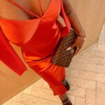 Jackie Aina Instagram - let me wear burnt orange ONE TIME 🤭 slip dress + cardigan: All Saints shoes + handbag: Chanel One Aldwych