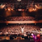 Jacob Collier Instagram - 91 shows. 28 countries. 15 humans. 150,000+ voices. The DJESSE World Tour 2022 is a wrap. My soul overflows - from the sheer power of all of you who came along, the most spectacular band and crew imaginable, the many Audience Choirs, the countless adventures with these songs and friends of mine. What an honour it’s been. To Robin, Christian, Bryn, Emily, Alita, Jose, Ale, Claudio, Luca, Regina, John, Fran, Rob and Ben – you have made the impossible possible and inspired me more than words can ever say, so here I’ll just say: THANK YOU. To all who came along to be a part of a show – thank you for reminding me just how much magic is in the world. It never ends. On a 25 hour plane trip home for Christmas, for some home-cooked food and some carol singing. Thank you all for an unfathomable, beautiful year 🫶🏼 The World