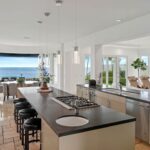 Jason Oppenheim Instagram - Just Listed - 22 Ritz Cove - $15,900,000 5 Beds / 5 Baths / 5,502 Sq. Ft. / 9,660 Lot Size Welcome to this exquisite oceanfront residence situated in the guard-gated community of Ritz Cove, one of the most sought-after coastal communities in Orange County where unrivaled luxury and exclusivity converge. Nestled between the iconic Ritz Carlton luxury hotel and the Monarch Beach Golf Course, this one-of-a-kind beachfront property offers breathtaking year-round views of sunsets over the break at Salt Creek Beach and Catalina Island from nearly every room in the home. Upon entering, you are enveloped by the welcoming, bright and airy floor plan and feel instantly at peace in your own private oasis. Five bedrooms and five bathrooms are spread across two levels, and a bonus room provides the flexibility to create a home office, media room, or gym. The large curved glass window in the kitchen invites the ocean inside, while the attached living room space creates an entertaining paradise that opens up onto the private patio with spa, setting the perfect stage for outdoor gatherings and sophisticated entertaining. The master suite is a true sanctuary, featuring an expansive bedroom and private balcony with sweeping views of the Pacific Ocean and the Ritz Carlton. The master bath boasts a lavish soaking tub for two, a separate shower, and exquisite dual vanities, all under a skylight that bathes the room in a glowing light. The suite extends into an extensive private master closet space apportioned with all the necessary amenities, including a 3-way mirror and attached locking closet. Additionally, a private stairway with a private gated entrance grants direct access to the pristine beach and countless walking trails directly from the backyard. This breathtaking beachfront property presents an unparalleled opportunity for a personal haven of relaxation and entertaining while offering the most captivating ocean and white-water views. Co-listed with @katinreinhardt Dana Point
