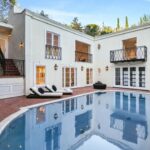 Jason Oppenheim Instagram - Just Listed Above The Sunset Strip - 1447 Queens Rd. - $3,495,000 2 Bed / 3 Bath / 2,307 Sq. Ft. Experience the epitome of glamour and sophistication with this stunningly restored Hollywood Regency replete with city views. Originally built by Robert Woolf alongside his partner, the legendary architect John Woolf, for their own personal residence, this property has recently undergone an artful restoration by renowned designer Tim Corrigan. Every detail has been meticulously considered to create an ultra-luxurious, alluring, and simply timeless atmosphere. Enter past the gated brick courtyard with fountain into the quintessential foyer featuring gorgeous black-and-white checkered marble floors. The main floor boasts a sitting room with beautiful crown molding and fireplace, along with an exquisite powder room with inlaid brass walls and an intricate one-of-a-kind medallion marble floor. The home has dual master suites (one on each floor) each equipped with their own ensuite baths that are strikingly finished with his-and-her sinks, built-in brass/silver fixtures, huge slabs of stone, and a plethora of closet space. Ascend the original brass railing staircase to the salon room, which features a second fireplace, French doors, and breathtaking city views. The large dining area and European kitchen with top-of-the-line appliances and backlit stone backsplash are perfect for entertaining. Outside, the private yard features a large pool, built-in BBQ, and mature hedging. A finished basement, along with a finished 2-car garage with French doors that lead to the yard, complete this remarkable property. Don’t miss this rare opportunity to own one of the most elegant and historic homes in Los Angeles.