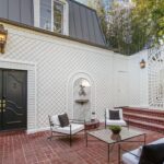 Jason Oppenheim Instagram - Just Listed Above The Sunset Strip - 1447 Queens Rd. - $3,495,000 2 Bed / 3 Bath / 2,307 Sq. Ft. Experience the epitome of glamour and sophistication with this stunningly restored Hollywood Regency replete with city views. Originally built by Robert Woolf alongside his partner, the legendary architect John Woolf, for their own personal residence, this property has recently undergone an artful restoration by renowned designer Tim Corrigan. Every detail has been meticulously considered to create an ultra-luxurious, alluring, and simply timeless atmosphere. Enter past the gated brick courtyard with fountain into the quintessential foyer featuring gorgeous black-and-white checkered marble floors. The main floor boasts a sitting room with beautiful crown molding and fireplace, along with an exquisite powder room with inlaid brass walls and an intricate one-of-a-kind medallion marble floor. The home has dual master suites (one on each floor) each equipped with their own ensuite baths that are strikingly finished with his-and-her sinks, built-in brass/silver fixtures, huge slabs of stone, and a plethora of closet space. Ascend the original brass railing staircase to the salon room, which features a second fireplace, French doors, and breathtaking city views. The large dining area and European kitchen with top-of-the-line appliances and backlit stone backsplash are perfect for entertaining. Outside, the private yard features a large pool, built-in BBQ, and mature hedging. A finished basement, along with a finished 2-car garage with French doors that lead to the yard, complete this remarkable property. Don’t miss this rare opportunity to own one of the most elegant and historic homes in Los Angeles.