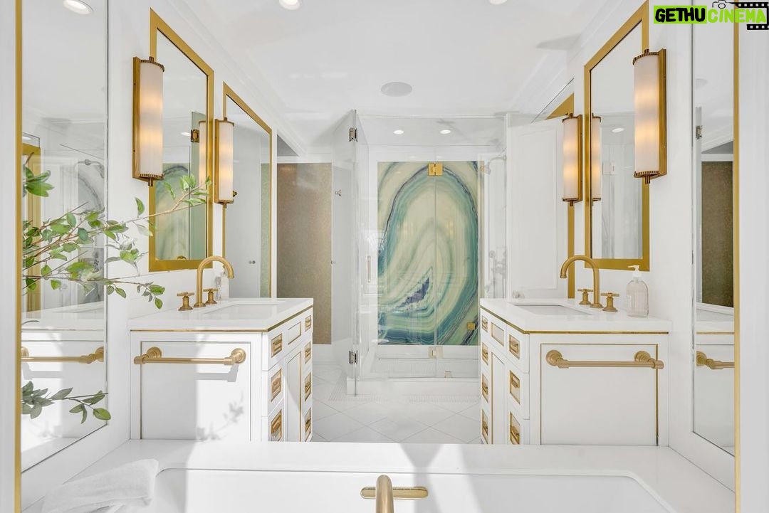 Jason Oppenheim Instagram - Just Listed Above The Sunset Strip - 1447 Queens Rd. - $3,495,000 2 Bed / 3 Bath / 2,307 Sq. Ft. Experience the epitome of glamour and sophistication with this stunningly restored Hollywood Regency replete with city views. Originally built by Robert Woolf alongside his partner, the legendary architect John Woolf, for their own personal residence, this property has recently undergone an artful restoration by renowned designer Tim Corrigan. Every detail has been meticulously considered to create an ultra-luxurious, alluring, and simply timeless atmosphere. Enter past the gated brick courtyard with fountain into the quintessential foyer featuring gorgeous black-and-white checkered marble floors. The main floor boasts a sitting room with beautiful crown molding and fireplace, along with an exquisite powder room with inlaid brass walls and an intricate one-of-a-kind medallion marble floor. The home has dual master suites (one on each floor) each equipped with their own ensuite baths that are strikingly finished with his-and-her sinks, built-in brass/silver fixtures, huge slabs of stone, and a plethora of closet space. Ascend the original brass railing staircase to the salon room, which features a second fireplace, French doors, and breathtaking city views. The large dining area and European kitchen with top-of-the-line appliances and backlit stone backsplash are perfect for entertaining. Outside, the private yard features a large pool, built-in BBQ, and mature hedging. A finished basement, along with a finished 2-car garage with French doors that lead to the yard, complete this remarkable property. Don’t miss this rare opportunity to own one of the most elegant and historic homes in Los Angeles.