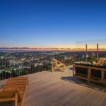 Jason Oppenheim Instagram - Just Listed - 8700 Franklin Ave. - $4,995,000 3 Bed / 3 Baths / 2,766 Sq. Ft. / 16,384 Lot Size Situated on its own promontory at the end of a quiet cul-de-sac street just above the Sunset Strip, this private mid-century home features unrivaled jetliner panoramic views of the entire city to the ocean. The swimmer's pool and outdoor patio evoke feelings of a five-star resort with an additional 20-foot waterfall, spa, and fire pit. Enter past the floor-to-ceiling front door to an open floor plan with a gorgeous living room, vaulted wood-beamed ceilings, a see-through fireplace, and a dining area with incredible views from every room. The sleek kitchen is complete with contemporary, top-of-the-line appliances. An additional bedroom, bathroom, and laundry room complete the main floor. A custom steel wall and floating staircase lead below to a large seating area and the luxurious owner's suite replete with a spa-like bathroom and walk-in closet, all opening to a massive deck. The third bedroom with an ensuite bath has floor-to-ceiling sliding doors perfect for an office or extra guest room. Detached 2-car garage and 2 uncovered parking spaces. The Sunset Strip