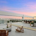 Jason Oppenheim Instagram - After two painstaking years and far too many millions of dollars, I have finally finished the remodel at the top floor of 7135 Hollywood Blvd., consisting of two beautiful penthouses, each offered at $7,495,000. Videos of each PH included in carousel. Penthouse East The most unique and exquisitely finished penthouse in all of Los Angeles, showcasing jetliner 360-degree views from the Hollywood sign to downtown and the ocean, as well as 2,885 sq. ft. of private outdoor deck space. Spanning half of the entire top floor in Hollywood's most exclusive full-service building (w/valet, doorman, and 24-hour security), Penthouse East has undergone a painstaking 2-year remodel to create the most sophisticated and mesmerizing residence in the entire city. Totaling 3,580 sq. ft. of interior living space with 3 bedrooms plus an office and 4 bathrooms, this penthouse is replete with an open living/dining room and built-in bar, floor-to-ceiling glass windows and sliding doors, exposed concrete beams, wide European oak flooring, and giant slabs of gorgeous Calacatta marble and Travertine limestone throughout. A chef’s kitchen is fitted with Gaggenau appliances and custom European cabinetry. The luxurious owner’s suite boasts a separate sitting area, fireplace, and ensuite bathroom with a free-standing soaking tub, spa-like shower, custom-cut Travertine sink, and an oversized showroom-style walk-in closet. The Penthouse offers smart home tech and two movie projector systems that drop from the ceiling, in both the living room and primary bedroom, with built-in surround sound. 4 dedicated parking spaces are included with the PH. Building amenities include a 24-hour valet, doorman, security, pool, recreation room, fitness center, dog park, and more. An unrivaled offering compared to other luxury condos when considering the design and quality of finishes, size/scale, unobstructed views, and outdoor deck space. Penthouse West (3,820 sq. ft. of interior living space with 1,685 sq. ft. exterior deck) is also available at $7,495,000, completing the entire top floor of the building. Thank you @whitegloveestates for the remodel and @vesta and @ashstaging for the amazing staging!! The Sunset Strip