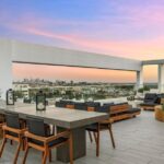 Jason Oppenheim Instagram - After two painstaking years and far too many millions of dollars, I have finally finished the remodel at the top floor of 7135 Hollywood Blvd., consisting of two beautiful penthouses, each offered at $7,495,000. Videos of each PH included in carousel. Penthouse East The most unique and exquisitely finished penthouse in all of Los Angeles, showcasing jetliner 360-degree views from the Hollywood sign to downtown and the ocean, as well as 2,885 sq. ft. of private outdoor deck space. Spanning half of the entire top floor in Hollywood's most exclusive full-service building (w/valet, doorman, and 24-hour security), Penthouse East has undergone a painstaking 2-year remodel to create the most sophisticated and mesmerizing residence in the entire city. Totaling 3,580 sq. ft. of interior living space with 3 bedrooms plus an office and 4 bathrooms, this penthouse is replete with an open living/dining room and built-in bar, floor-to-ceiling glass windows and sliding doors, exposed concrete beams, wide European oak flooring, and giant slabs of gorgeous Calacatta marble and Travertine limestone throughout. A chef’s kitchen is fitted with Gaggenau appliances and custom European cabinetry. The luxurious owner’s suite boasts a separate sitting area, fireplace, and ensuite bathroom with a free-standing soaking tub, spa-like shower, custom-cut Travertine sink, and an oversized showroom-style walk-in closet. The Penthouse offers smart home tech and two movie projector systems that drop from the ceiling, in both the living room and primary bedroom, with built-in surround sound. 4 dedicated parking spaces are included with the PH. Building amenities include a 24-hour valet, doorman, security, pool, recreation room, fitness center, dog park, and more. An unrivaled offering compared to other luxury condos when considering the design and quality of finishes, size/scale, unobstructed views, and outdoor deck space. Penthouse West (3,820 sq. ft. of interior living space with 1,685 sq. ft. exterior deck) is also available at $7,495,000, completing the entire top floor of the building. Thank you @whitegloveestates for the remodel and @vesta and @ashstaging for the amazing staging!! The Sunset Strip