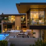 Jason Oppenheim Instagram - Just Listed in Manhattan Beach - 1001 1st St. - $29,900,000 6 Beds / 9 Baths / 9,479 Sq. Ft. The most impressive and high-quality Contemporary estate ever built in Manhattan Beach, featuring panoramic ocean views from every room. After a laborious multi-year build, this approximately 9,500 sq. ft. showstopper seamlessly fuses glass, cedar, and concrete into a triumphant architectural tour de force with a sense of permanence and grandeur. Integral to the structure and aesthetic of the home, the scalloped concrete walls seen on the exterior and interior walls resemble an undulating wave-like texture accomplished by custom milled formwork which complement the surrounding Pacific landscape. Custom cedar clads the remaining walls and ceilings, bringing warmth and visual impact throughout the sleek space. Double-height ceilings and oversized automated Otiima pocketing doors and windows create a sense of expansion within, as the home seamlessly unfolds into an extensive beautifully landscaped outdoor terrace and pool/spa perfect for California living. An additional shaded patio with fireplace is created by the deep cedar overhangs from the upper floor and the roof. Generously nestled on an extra-wide corner lot, the home is replete with 6 bedrooms plus an additional office/nursery, 9 bathrooms, home theater, game room, wine cellar, wet bar, and gym, with architecture by Laney LA. Additional amenities include 48 solar panels with Tesla Powerwalls, elevator, 14 zone A/C technology platform system, Control4 home automation, and 3-car garage with additional driveway parking. An exceptionally rare opportunity to own a meticulously crafted beach estate with soul and sophistication. Manhattan Beach, California