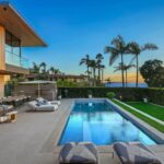 Jason Oppenheim Instagram - Just Listed in Manhattan Beach - 1001 1st St. - $29,900,000 6 Beds / 9 Baths / 9,479 Sq. Ft. The most impressive and high-quality Contemporary estate ever built in Manhattan Beach, featuring panoramic ocean views from every room. After a laborious multi-year build, this approximately 9,500 sq. ft. showstopper seamlessly fuses glass, cedar, and concrete into a triumphant architectural tour de force with a sense of permanence and grandeur. Integral to the structure and aesthetic of the home, the scalloped concrete walls seen on the exterior and interior walls resemble an undulating wave-like texture accomplished by custom milled formwork which complement the surrounding Pacific landscape. Custom cedar clads the remaining walls and ceilings, bringing warmth and visual impact throughout the sleek space. Double-height ceilings and oversized automated Otiima pocketing doors and windows create a sense of expansion within, as the home seamlessly unfolds into an extensive beautifully landscaped outdoor terrace and pool/spa perfect for California living. An additional shaded patio with fireplace is created by the deep cedar overhangs from the upper floor and the roof. Generously nestled on an extra-wide corner lot, the home is replete with 6 bedrooms plus an additional office/nursery, 9 bathrooms, home theater, game room, wine cellar, wet bar, and gym, with architecture by Laney LA. Additional amenities include 48 solar panels with Tesla Powerwalls, elevator, 14 zone A/C technology platform system, Control4 home automation, and 3-car garage with additional driveway parking. An exceptionally rare opportunity to own a meticulously crafted beach estate with soul and sophistication. Manhattan Beach, California