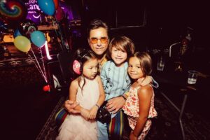 John Stamos Instagram - I thank my beautiful wife who knows how to throw a party - Fake Beatles, @raintribute (the best Beatles band ever!) Real Beach Boys, @mikeloveofficial @jamieleecurtis handing out @stamos bracelets, @glenpowell riding some big cow-like animal, all my friends, family, (party crashers) it was a 60’s party that was better than the actual 60’s ! 📸 @micalaaustin @canyonagoura THANK YOU!