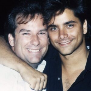 John Stamos Instagram - Today, I lost more than a friend; I lost a part of my soul, my history - Jeffrey Foskett, my dearest friend, brother, and the brightest light in my life, has left this world. 

This morning, when I got the news, uncontrollable tears streamed down my face, a physical manifestation of the heartache within. 

My son Billy heard my cries, joined my wife in holding me up, and then ran off, only to return with a small, tender offering – a drawing. His innocent hands sketched a picture of Jeff with hearts ascending to heaven, with me, waving goodbye. A stairway of hearts, and next to the top heart, he wrote God. A simple yet powerful symbol of love and loss that pierced through my grief.

Jeff was more than just a friend; he was the one who brought the harmonies of The Beach Boys into my life, and with them, a spectrum of color and joy I never dreamed would be part of my life. 

He was a vibrant force, a radiant soul whose laughter and wisdom touched everyone he met. He was an older brother in spirit, guiding, lifting, and loving me, sometimes more than I thought I deserved.

Jeff taught me that love is a beautiful and necessary part of our lives, but it comes with a cost—the unbearable pain of loss. It's the kind of pain that can make us question whether we should ever allow ourselves to love so deeply, so completely. Should we keep our walls up and shield our hearts from the world in an attempt to avoid the sharp, immense sorrow that follows when we say goodbye to someone we hold dear?

But then, as I reflect on Jeff's remarkable life and the profound impact he had on mine, I realize that this pain is the price we pay for the privilege of knowing and loving someone like him. Yes, the pain is excruciating and cuts deep into our souls, but it is a testament to the depth of our connection.

Yet, when I think of the 40 years we shared – the uproarious laughter, the music that we believed changed lives, and the unshakable bond of brotherhood – I can't help but feel grateful. Grateful for every moment, every note, every piece of wisdom he shared with me.  CONT.