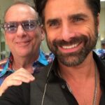 John Stamos Instagram - Today, I lost more than a friend; I lost a part of my soul, my history - Jeffrey Foskett, my dearest friend, brother, and the brightest light in my life, has left this world.  This morning, when I got the news, uncontrollable tears streamed down my face, a physical manifestation of the heartache within.  My son Billy heard my cries, joined my wife in holding me up, and then ran off, only to return with a small, tender offering – a drawing. His innocent hands sketched a picture of Jeff with hearts ascending to heaven, with me, waving goodbye. A stairway of hearts, and next to the top heart, he wrote God. A simple yet powerful symbol of love and loss that pierced through my grief. Jeff was more than just a friend; he was the one who brought the harmonies of The Beach Boys into my life, and with them, a spectrum of color and joy I never dreamed would be part of my life.  He was a vibrant force, a radiant soul whose laughter and wisdom touched everyone he met. He was an older brother in spirit, guiding, lifting, and loving me, sometimes more than I thought I deserved. Jeff taught me that love is a beautiful and necessary part of our lives, but it comes with a cost—the unbearable pain of loss. It's the kind of pain that can make us question whether we should ever allow ourselves to love so deeply, so completely. Should we keep our walls up and shield our hearts from the world in an attempt to avoid the sharp, immense sorrow that follows when we say goodbye to someone we hold dear? But then, as I reflect on Jeff's remarkable life and the profound impact he had on mine, I realize that this pain is the price we pay for the privilege of knowing and loving someone like him. Yes, the pain is excruciating and cuts deep into our souls, but it is a testament to the depth of our connection. Yet, when I think of the 40 years we shared – the uproarious laughter, the music that we believed changed lives, and the unshakable bond of brotherhood – I can't help but feel grateful. Grateful for every moment, every note, every piece of wisdom he shared with me. CONT.