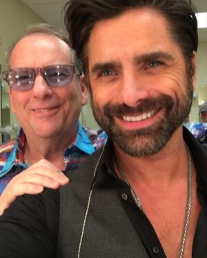 John Stamos Instagram - Today, I lost more than a friend; I lost a part of my soul, my history - Jeffrey Foskett, my dearest friend, brother, and the brightest light in my life, has left this world. 

This morning, when I got the news, uncontrollable tears streamed down my face, a physical manifestation of the heartache within. 

My son Billy heard my cries, joined my wife in holding me up, and then ran off, only to return with a small, tender offering – a drawing. His innocent hands sketched a picture of Jeff with hearts ascending to heaven, with me, waving goodbye. A stairway of hearts, and next to the top heart, he wrote God. A simple yet powerful symbol of love and loss that pierced through my grief.

Jeff was more than just a friend; he was the one who brought the harmonies of The Beach Boys into my life, and with them, a spectrum of color and joy I never dreamed would be part of my life. 

He was a vibrant force, a radiant soul whose laughter and wisdom touched everyone he met. He was an older brother in spirit, guiding, lifting, and loving me, sometimes more than I thought I deserved.

Jeff taught me that love is a beautiful and necessary part of our lives, but it comes with a cost—the unbearable pain of loss. It's the kind of pain that can make us question whether we should ever allow ourselves to love so deeply, so completely. Should we keep our walls up and shield our hearts from the world in an attempt to avoid the sharp, immense sorrow that follows when we say goodbye to someone we hold dear?

But then, as I reflect on Jeff's remarkable life and the profound impact he had on mine, I realize that this pain is the price we pay for the privilege of knowing and loving someone like him. Yes, the pain is excruciating and cuts deep into our souls, but it is a testament to the depth of our connection.

Yet, when I think of the 40 years we shared – the uproarious laughter, the music that we believed changed lives, and the unshakable bond of brotherhood – I can't help but feel grateful. Grateful for every moment, every note, every piece of wisdom he shared with me.  CONT.