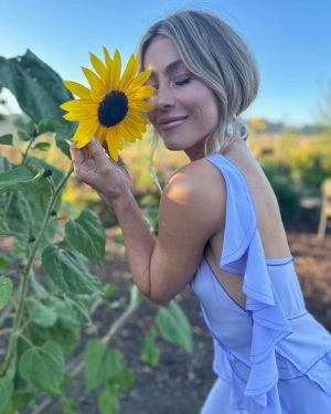 Julianne Hough Instagram - A few of my favorite things… sunflowers and a beautiful @victoriabeckham dress 🌻💜

Sunflowers are some of the most magical flowers I’ve come across, which is why they’re my favorite. They always turn to face the sun and they’re known as a symbol for hope, healing and joy - something I always strive to have in my life and surround myself with. Even named my little one Sunny ☀️🐶