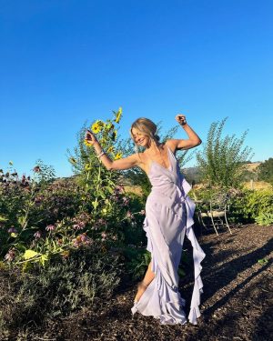 Julianne Hough Instagram - A few of my favorite things… sunflowers and a beautiful @victoriabeckham dress 🌻💜

Sunflowers are some of the most magical flowers I’ve come across, which is why they’re my favorite. They always turn to face the sun and they’re known as a symbol for hope, healing and joy - something I always strive to have in my life and surround myself with. Even named my little one Sunny ☀️🐶