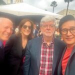 Ke Huy Quan Instagram - Indy will always be a hero to Short Round and Harrison Ford will always be a hero to me❣️ I wish he could continue in this role forever, but I was happy to be there last night to see him crack that whip one more time. Dial of Destiny is SO GOOD!!! Please go see it comes June 30th! (Can you spot another cast member from Temple of Doom? Hint: he loves voodoo dolls 😜) 📸: @gettyimages Styling: @chloekeiko Grooming: @sonialeeartistry Outfit: @paulsmithdesign Glasses: @cutlerandgross Watch: @omega Shoes: @churchs @indianajones @lucasfilm @disney