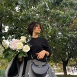 Léna Mahfouf Instagram - entourée de fleurs, je me sens bien 💐👜 @prada #PradaArqué #PradaFW23 collaboration commerciale colorimétrie retouchée Paris, France