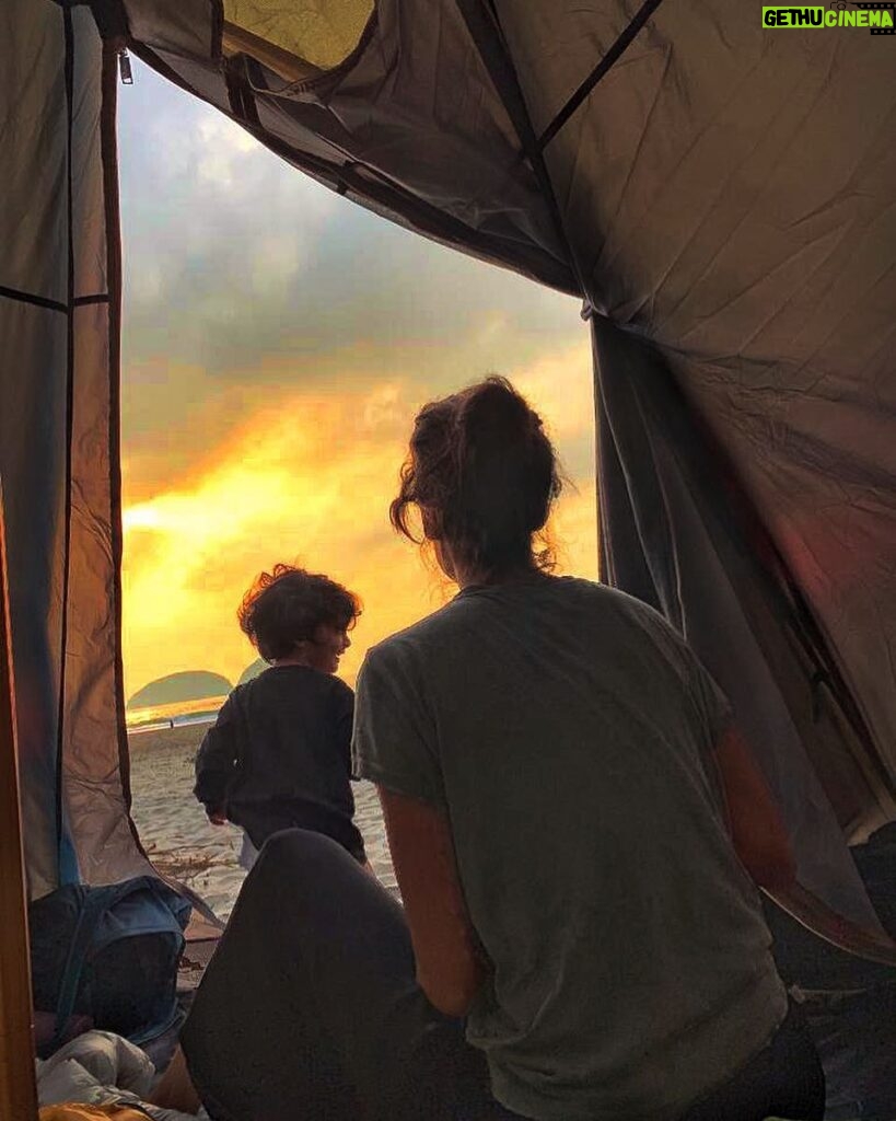 Lisa Haydon Instagram - Very proud of how we pulled off this weekends camping trip. Spending 4 hours in the equipment store figuring out the right tent for a family, testing the lightest mattresses to carry with most sleeping comfort- efforts aside, our comfort level was extremely low😂. Camping on the beach looks a lot better than it feels. Yet, struggling to keep our fire going in extreme wind, trying to explain to our son that this is our whole house for now, and we must not throw sand in it as we have to sleep in it, being attacked by wild boars, plus carrying the weight of our children up and down a mountain- all feels surreal. And as our only toilet paper roll flapped in the wind hanging from a piece of metal off our make-shift stove I reminded myself that “Simplicity is the ultimate Sophistication”. Of course no one needed reminding come sunrise 🌅