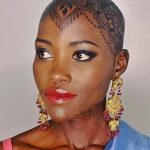 Lupita Nyong’o Instagram – THE STORY OF MY HEAD: 
I met @hennabysabeen last year at a wedding in Pakistan. She did the #HennaDesign for the bride and I was ASTOUNDED by the INTRICACY and BEAUTY of her work. There was something unique about the way she expressed herself in henna art. And I promised myself, “One day I will have a reason to work with Sabeen.”
:
1.5 years later, when I got the invitation to attend the opening night of my dear friend, Mira Nair’s @monsoonmusical, I was scrambling at the last minute to find something to wear. I borrowed a sari and jewelry from @mishajapanwala, the bride from Pakistan, but the look didn’t feel complete…
:
And then, in the middle of the night, an image SHOT into my mind of a henna design covering my bald head!!! I could do something special and different, to celebrate the culture using the canvas readily available to me! I was so excited by the idea that I could not go back to sleep. Misha connected me to Sabeen, and we were ON OUR WAY…
:
Sabeen had NEVER designed for a head before; I had never done such a thing before either. My only prompt to her was that I wanted a widow’s peak (homage to the bindhi, borla / maang tikka), the rest was ALL HER INNOVATION.  She suggested #jagua, a natural dye from the jagua fruit of South America that would be dark enough to give good contrast to my dark skin ☺️. 
:
We were both excited and terrified. What if it went wrong or looked funny??? Well, I thought, I can always wear a head wrap…. 
:
But Sabeen BROUGHT IT! We stopped now and again so that I could give her feedback because she was DETERMINED to leave me a happy client. And Sabeen was METICULOUS. She did not stop until it was perfect. When we looked at the finished head… we were both GRINNING!
:
It takes about 24 hours for the dye to really show up. And when it came in, in FULL CONTRAST the next day, I was simply MOVED. It was beautiful. It was bold and elegant; it had a point of view. We had not played it safe, and it had paid off. And I had found a new way to express myself without hair! 
:
So the moral of this story is: DARE YOURSELF TO SEEK OUT BEAUTY IN NEW WAYS. And, Sabeen, thank you for bestowing on me the beauty of your hand and history!
