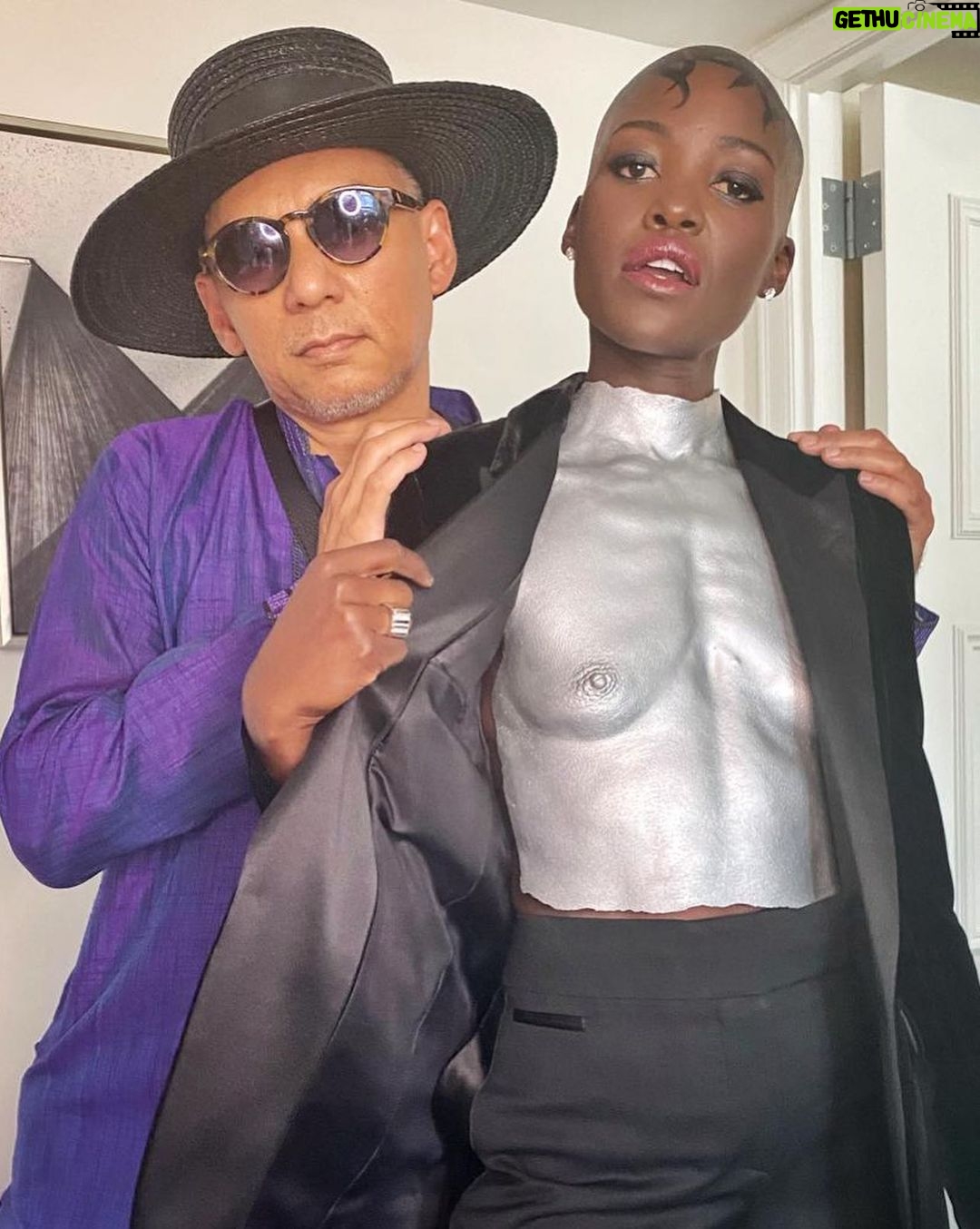 Lupita Nyong'o Instagram - Tonys BTS with the team! For big nights and small ones too, I love the little details as commemorations to take in and appreciate life experiences. I’m so grateful for the collaborators who brought their individual talents to make a collective statement on Tonys Night. We made the day a big party to celebrate our dear Saheem and theater’s ability to bring people together in shared spaces, to think, feel, learn, laugh, wonder and love! Here’s to THAT! ❤️ 🎭 1: The squad! 🙏🏿 2: @nickbarose who brings an endlessly inspired hand to eyes, lips, face, and cheeks! 💄 3: The birthday girl and stylist, @micaela, who Fairy Godmother to both me and @saheemscene on his big night. 🧁🌟 4: Jewelry by @debeersofficial RVL Collection. Complimentary manicure by @sonyameesh 🩶🩶 5: @mishajapanwala! Y’all know who she is now! 🎽🩻 🙌🏿 6: Henna head art by @hennabysabeen with clean shave by @mrbarberj. Keep scrolling to read about Sabeen’s homage to East African and South Asian cultures in her design. 🌍🌏 7: Our Tony nominee and Our Plus-Ones: @saheemscene! @dedeayitedesign @michaelthurber ❤️❤️❤️ 8: A Saheem Photo Cake! Courtesy of @creeinnyc! 🍰 🖌️HENNA ART INSPIRATION: We had the words sculptural, sharp & solid as our guides to compliment Misha's work. And then I visited the Kenyan artist, Wangechi Mutu's exhibition entitled INTERTWINED, and it all solidified for us! Wangechi, like Misha interrogates the representation of the female body, and in her piece, In Two Canoe the human body morphs into the plant body, exploring a fantastical hybridity that alludes to "the fertility, femininity and symbiosis captured in the object's very doubled form." So, we went with a leaves motif because of their ability to be both geometric and organic. They grow within the bounds of a very elaborate system and are still able to improvise to INSIST on their survival and growth, and that's exactly what I am keen to do in this season of my life. There's also a quiet homage to the kofia/kufi worn in both our East African and South Asian cultures as well as it being a symbol of African-American pride - a salute to our new homeland! 