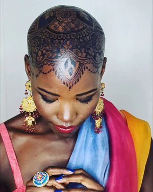 Lupita Nyong'o Instagram - THE STORY OF MY HEAD: 
I met @hennabysabeen last year at a wedding in Pakistan. She did the #HennaDesign for the bride and I was ASTOUNDED by the INTRICACY and BEAUTY of her work. There was something unique about the way she expressed herself in henna art. And I promised myself, "One day I will have a reason to work with Sabeen."
:
1.5 years later, when I got the invitation to attend the opening night of my dear friend, Mira Nair's @monsoonmusical, I was scrambling at the last minute to find something to wear. I borrowed a sari and jewelry from @mishajapanwala, the bride from Pakistan, but the look didn't feel complete...
:
And then, in the middle of the night, an image SHOT into my mind of a henna design covering my bald head!!! I could do something special and different, to celebrate the culture using the canvas readily available to me! I was so excited by the idea that I could not go back to sleep. Misha connected me to Sabeen, and we were ON OUR WAY...
:
Sabeen had NEVER designed for a head before; I had never done such a thing before either. My only prompt to her was that I wanted a widow's peak (homage to the bindhi, borla / maang tikka), the rest was ALL HER INNOVATION.  She suggested #jagua, a natural dye from the jagua fruit of South America that would be dark enough to give good contrast to my dark skin ☺️. 
:
We were both excited and terrified. What if it went wrong or looked funny??? Well, I thought, I can always wear a head wrap.... 
:
But Sabeen BROUGHT IT! We stopped now and again so that I could give her feedback because she was DETERMINED to leave me a happy client. And Sabeen was METICULOUS. She did not stop until it was perfect. When we looked at the finished head... we were both GRINNING!
:
It takes about 24 hours for the dye to really show up. And when it came in, in FULL CONTRAST the next day, I was simply MOVED. It was beautiful. It was bold and elegant; it had a point of view. We had not played it safe, and it had paid off. And I had found a new way to express myself without hair! 
:
So the moral of this story is: DARE YOURSELF TO SEEK OUT BEAUTY IN NEW WAYS. And, Sabeen, thank you for bestowing on me the beauty of your hand and history!