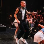 Macklemore Instagram – After a couple off days back in Seattle I landed in phoenix and was greeted by a sizzling 102 degree sun. I decided to dress up like a falcon wrangler. I met people outside that had been waiting since 9:30am to get in.  We hugged, shed some tears and I felt really good in the spirit. The venue was air conditioned and dog friendly prolly. Just had that vibe that if you were a dog they’d let you chill in a hallway and give you a mini Mars bar or some shit. Anyway, I hit the stage in my falcon handling gloves and immediately felt restricted by the big tough leather covering my palms. After the first song they had to go. Bam! Threw them shits. The crowd was loose and nibble as was I, well hydrated and relatively sturdy. I was hitting a lot of spin moves to showcase how hydrated I actually was all while thinking in my head “You still got it my boy”. We laughed and some of my jokes hit. Some didn’t.  Some people yawned. That always throws me off, so if you come to a show and you’re tired please hold that shit in. Anyway, the whole crowd was full of love and they sent us off stage with smiles and daps. Beautiful evening with the Cacti loving folks of Arizona. Next stop…LA for our finale show tonight.