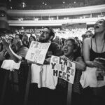 Macklemore Instagram – After a couple off days back in Seattle I landed in phoenix and was greeted by a sizzling 102 degree sun. I decided to dress up like a falcon wrangler. I met people outside that had been waiting since 9:30am to get in.  We hugged, shed some tears and I felt really good in the spirit. The venue was air conditioned and dog friendly prolly. Just had that vibe that if you were a dog they’d let you chill in a hallway and give you a mini Mars bar or some shit. Anyway, I hit the stage in my falcon handling gloves and immediately felt restricted by the big tough leather covering my palms. After the first song they had to go. Bam! Threw them shits. The crowd was loose and nibble as was I, well hydrated and relatively sturdy. I was hitting a lot of spin moves to showcase how hydrated I actually was all while thinking in my head “You still got it my boy”. We laughed and some of my jokes hit. Some didn’t.  Some people yawned. That always throws me off, so if you come to a show and you’re tired please hold that shit in. Anyway, the whole crowd was full of love and they sent us off stage with smiles and daps. Beautiful evening with the Cacti loving folks of Arizona. Next stop…LA for our finale show tonight.